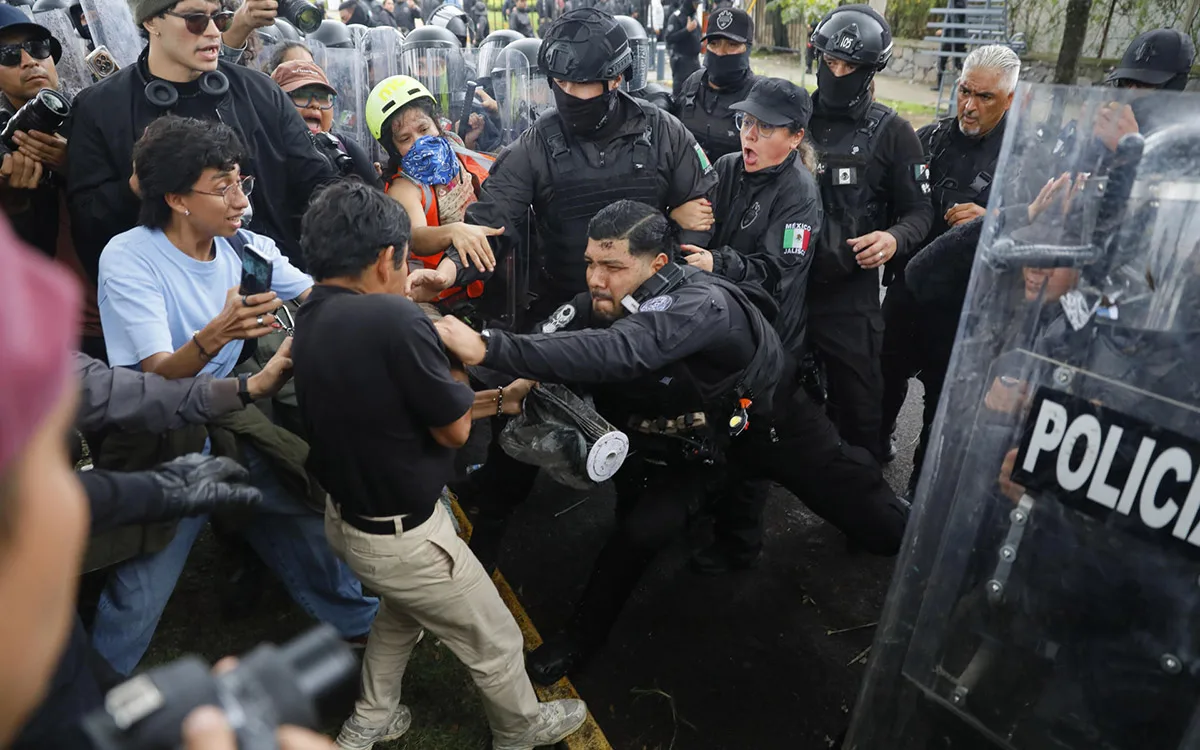 Un policía intentando jalar a un manifestante hacia el punto policial dentro de Casa Jalisco. Foto: Cortesía.